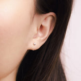 Fine jewellery, silver jewellery, hypoallergenic, tarnish-free, Close-up front view of an ear wearing a small silver stud earring with a blurred background